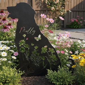 May include: Black metal dog silhouette garden stake with floral and butterfly cutouts. The name "Molly" is scripted on the dog. The stake is surrounded by colorful flowers, including pink coneflowers and daisies, in a garden setting.