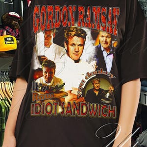 May include: Black t-shirt with a collage of Gordon Ramsay images and the text "GORDON RAMSAY RAW IDIOT SANDWICH" in red and white. The shirt is dark and appears to be a unisex style.