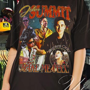 May include: A black t-shirt with a graphic of a band, the word "SUMMIT" in orange and red, and the text "Wake Me Up". The design has a vintage, worn appearance, typical of retro band merchandise.