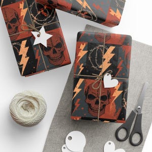 以下が含まれることがあります： 黒、オレンジ、グレーの頭蓋骨、稲妻、有刺鉄線の繰り返し模様のギフト包装された箱。 各箱は紐と白いタグで結ばれています。 紐のボール、ハサミ、空白のタグも表示されています。