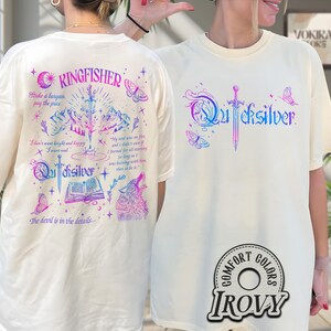 Pu&ograve; includere: T-shirt color avorio con la scritta "Quicksilver" in un gradiente blu e viola e una grafica a spada. Il retro della maglietta presenta la scritta "Kingfisher" e grafiche aggiuntive, tra cui un lupo, farfalle e testo. Le magliette hanno un logo Comfort Colors e IROVY.