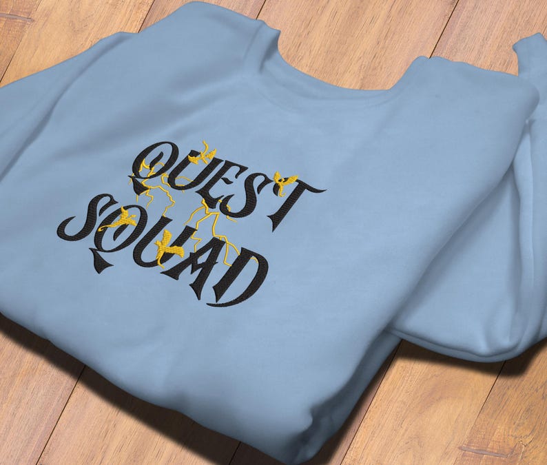 May include: A light blue sweatshirt with the text "QUEST SQUAD" in black lettering with gold accents.