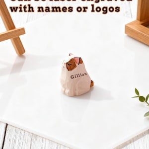 May include: A wooden cat figurine with brown and white markings, engraved with the name "Gillian." The figurine is on a white surface. Text above reads "Can be laser engraved with names or logos."