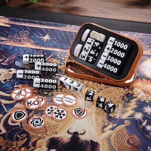 Könnte beinhalten: Ein Tischspiel-Set mit Würfeln, Zählern und einem Punktezähler. Der Punktezähler ist eine kleine, rechteckige, kupferfarbene Box mit weißen und schwarzen Zahlentafeln. Die Würfel sind schwarz mit weißen Zahlen. Zähler sind weiß mit orangefarbenen und schwarzen Symbolen.