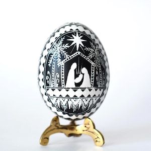 Handgeschilderd kerststal met Pysanka-eieren: scène heilige familie