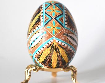 Huevo de Pascua pysanka ucraniano en batik: adorno artesanal de cáscara de huevo con tallo de trigo en azul y dorado