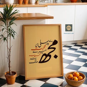 Puede incluir: Una impresión enmarcada con caligrafía negra y roja sobre un fondo beige. La impresión está apoyada contra una pared blanca y un suelo a cuadros en blanco y negro. Una pequeña planta en maceta y una cesta de naranjas están en primer plano.