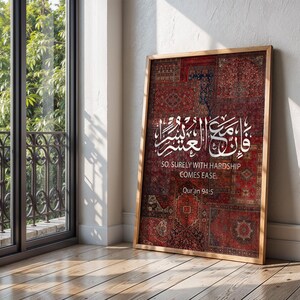 Pu&ograve; includere: Una stampa incorniciata con un patchwork di motivi di tappeti rossi e bordeaux. L'opera presenta una calligrafia araba bianca e la traduzione inglese: "So, surely with hardship comes ease". &Egrave; incluso anche il testo "Qur'an 94:5".
