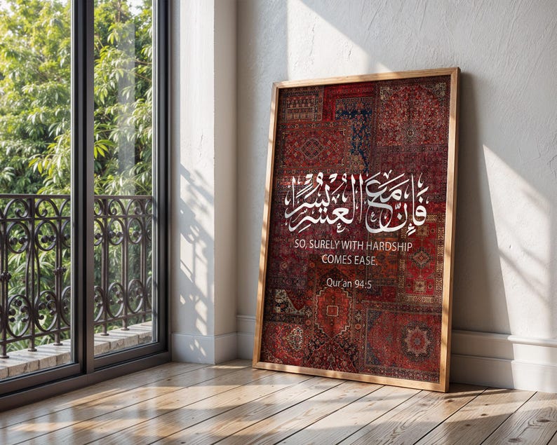 Pu&ograve; includere: Una stampa incorniciata con un patchwork di motivi di tappeti rossi e bordeaux. L'opera presenta una calligrafia araba bianca e la traduzione inglese: "So, surely with hardship comes ease". &Egrave; incluso anche il testo "Qur'an 94:5".