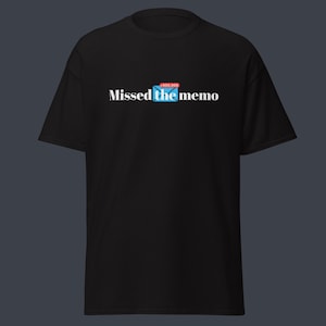 May include: Black t-shirt with the text "Missed the memo" in white, above a blue envelope icon with a red notification. The shirt is a casual style, suitable for everyday wear.