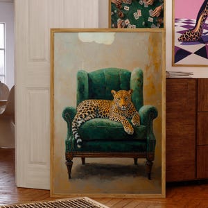 Puede incluir: Una obra de arte enmarcada con un leopardo descansando en un sillón verde. Arte enmarcado adicional incluye un zapato de tacón alto con estampado de leopardo y una escena de juego de póquer. La habitación tiene pisos de madera y un armario de madera.