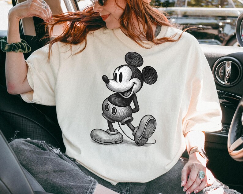 Puede incluir: Camiseta color crema con una ilustraci&oacute;n en blanco y negro de Mickey Mouse. El personaje de dibujos animados se representa en una pose cl&aacute;sica, sonriendo. La camiseta tiene un corte casual y oversize.