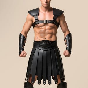 Peut inclure: Costume de gladiateur en cuir noir avec une armure d'épaule, un harnais de poitrine avec une boucle, des brassards et une jupe plissée. Thème romain.