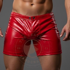 Könnte beinhalten: Glänzende rote Leder-Shorts mit Knopfverschluss. Die Shorts haben ein figurbetontes Design und ein glänzendes Finish. Das Bild enthält ein Logo mit dem Text "THE LEATHER HANDCRAFT".