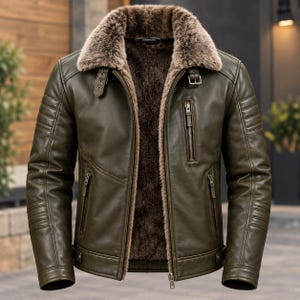 May include: An olive green leather jacket featuring a thick, brown faux fur lining and a matching fur collar. The jacket includes a front zipper closure, three zippered pockets, and adjustable buckle straps at the collar and the waist hem.