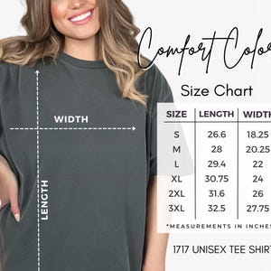 May include: A dark grey short-sleeved t-shirt with a size chart graphic labeled Comfort Colors. The chart lists sizes S through 3XL with corresponding length and width measurements in inches. The text 1717 UNISEX TEE SHIRT is visible at the bottom.