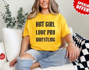 Op de afbeelding: Een geel T-shirt met zwarte tekst die "HOT GIRL LOVE PRO WRESTLING" zegt.