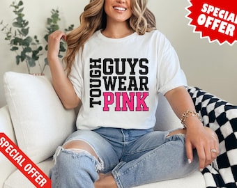 Op de afbeelding: Wit T-shirt met de tekst "TOUGH GUYS WEAR PINK" in zwarte en roze blokletters. Het shirt wordt gedragen met een blauwe jeans. Een rode "SPECIAL OFFER" banner staat in de hoek.