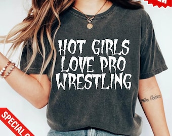 Op de afbeelding: Een donkergrijs T-shirt met de tekst "HOT GIRLS LOVE PRO WRESTLING" in wit.