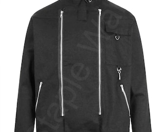 May include: Black jacket with a high collar, multiple silver zippers, and a small pocket. The jacket features a unique design with silver hardware, including a ring detail at the collar and a belt loop at the waist. The jacket is a solid black color.