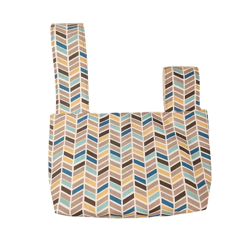 May include: A beige fabric bag with two straps. The bag has a chevron pattern in shades of brown, blue, and yellow.
