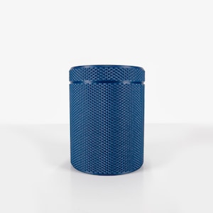 Puede incluir: Un rodillo de espuma azul con una superficie texturizada. El rodillo está diseñado para la recuperación muscular y el estiramiento.