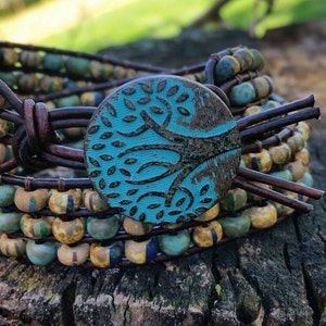 May include: A multi-strand leather wrap bracelet with turquoise and brown beads and a turquoise tree of life charm.