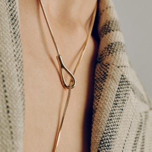 Adjustable knot layered necklace with a Y-lariat drop chain and a gold or silver toggle pendant. Versatile design can be worn long, as a choker, or layered with other necklaces. A minimalist long drop chain necklace perfect for everyday wear, Thanksgiving gatherings, Christmas parties, New Year celebrations, and holiday gifting.