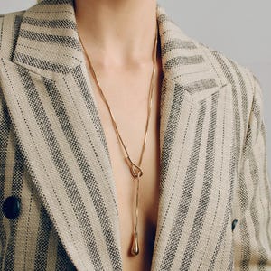 Adjustable knot layered necklace with a Y-lariat drop chain and a gold or silver toggle pendant. Versatile design can be worn long, as a choker, or layered with other necklaces. A minimalist long drop chain necklace perfect for everyday wear, Thanksgiving gatherings, Christmas parties, New Year celebrations, and holiday gifting.