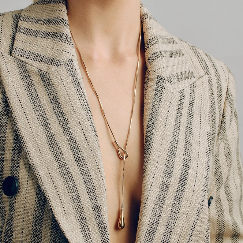 Adjustable knot layered necklace with a Y-lariat drop chain and a gold or silver toggle pendant. Versatile design can be worn long, as a choker, or layered with other necklaces. A minimalist long drop chain necklace perfect for everyday wear, Thanksgiving gatherings, Christmas parties, New Year celebrations, and holiday gifting.