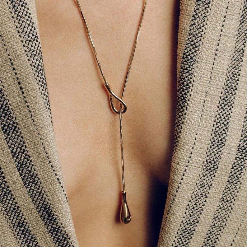 Adjustable knot layered necklace with a Y-lariat drop chain and a gold or silver toggle pendant. Versatile design can be worn long, as a choker, or layered with other necklaces. A minimalist long drop chain necklace perfect for everyday wear, Thanksgiving gatherings, Christmas parties, New Year celebrations, and holiday gifting.
