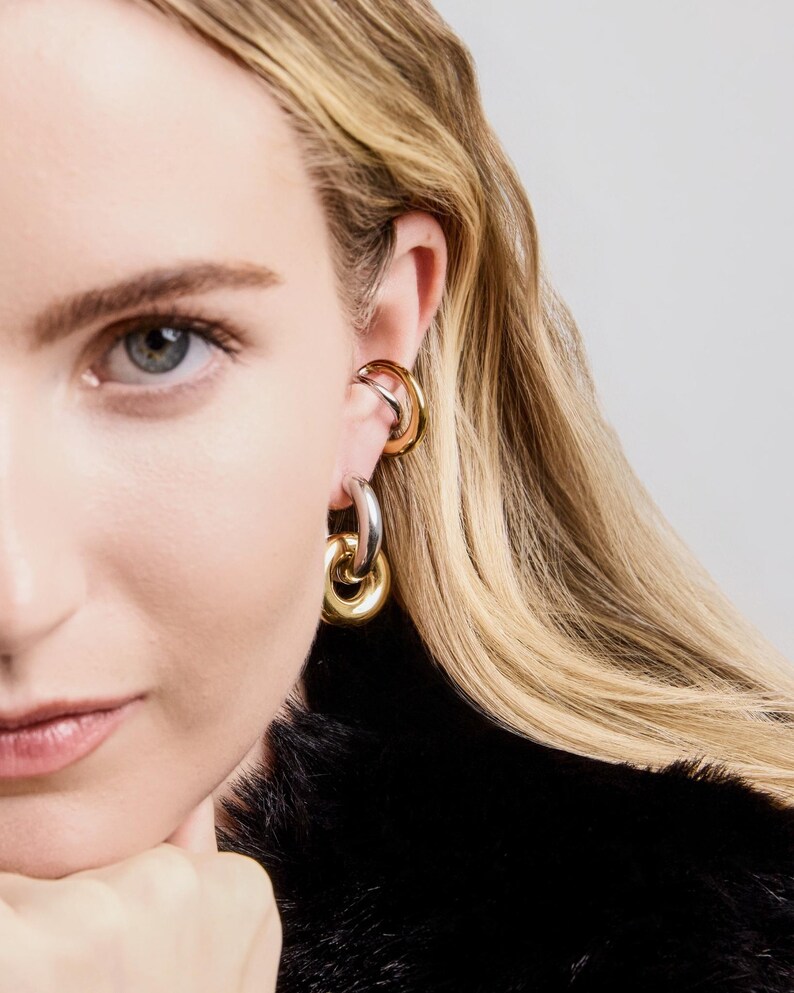 old and silver mixed metal link earrings worn on ear, bold chunky hoop earrings with polished finish.