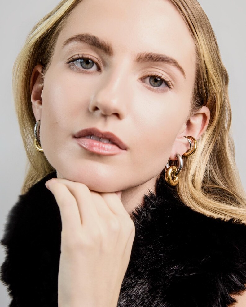 old and silver mixed metal link earrings worn on ear, bold chunky hoop earrings with polished finish.
