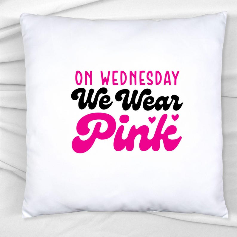 以下が含まれることがあります： 黒とピンクの文字で「On Wednesday We Wear Pink」と書かれた白い枕