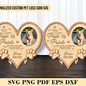 Könnte beinhalten: Ein herzförmiges Schild aus Holz mit einem Pfotenabdruck-Design und dem Text "You Left Paw Prints On My Heart Forever". Das Schild enthält auch ein Foto eines Hundes und den Namen "George" mit Daten.
