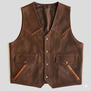 May include: A brown leather vest with a V-neck and four brass-colored buttons. The vest has two front pockets and tan-colored trim along the collar and pockets. The vest is made of a distressed leather material.