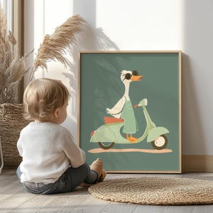 Puede incluir: Una impresi&oacute;n art&iacute;stica enmarcada que presenta un ganso de dibujos animados con gafas de sol y un mono, montado en una scooter verde menta. La obra de arte tiene un fondo verde y un marco de madera. Un ni&ntilde;o est&aacute; sentado en el suelo frente a la obra.