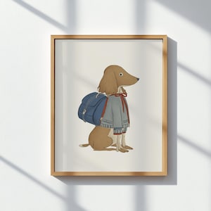 May include: A framed print featuring a brown dog wearing a gray sweater, red bow, and a blue backpack. The dog is sitting, facing right, with a neutral background. The artwork has a whimsical, illustrated style.