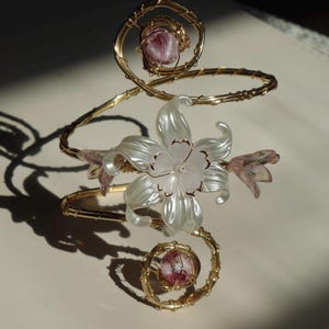 Pulseira de punho com flores rosa e de cerejeira em ouro rosa.