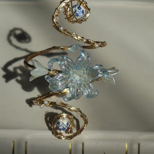 Pulseira de punho com flor dourada em azul acinzentado