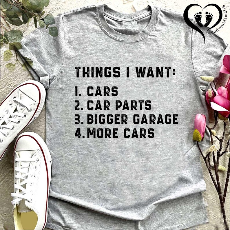 Puede incluir: Camiseta gris con el texto "THINGS I WANT: 1. CARS 2. CAR PARTS 3. BIGGER GARAGE 4. MORE CARS" impreso en negro.