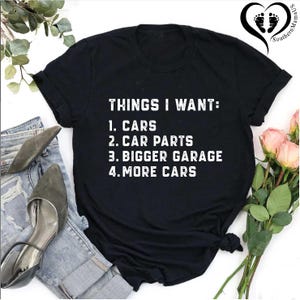 Puede incluir: Camiseta negra con texto blanco que dice "THINGS I WANT: 1. CARS 2. CAR PARTS 3. BIGGER GARAGE 4. MORE CARS"