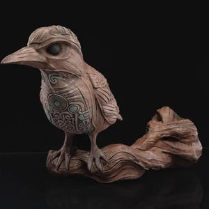 May include: A detailed ceramic sculpture of a bird perched on a branch. The bird is brown with intricate carvings and a light blue design. The branch is also brown and textured.