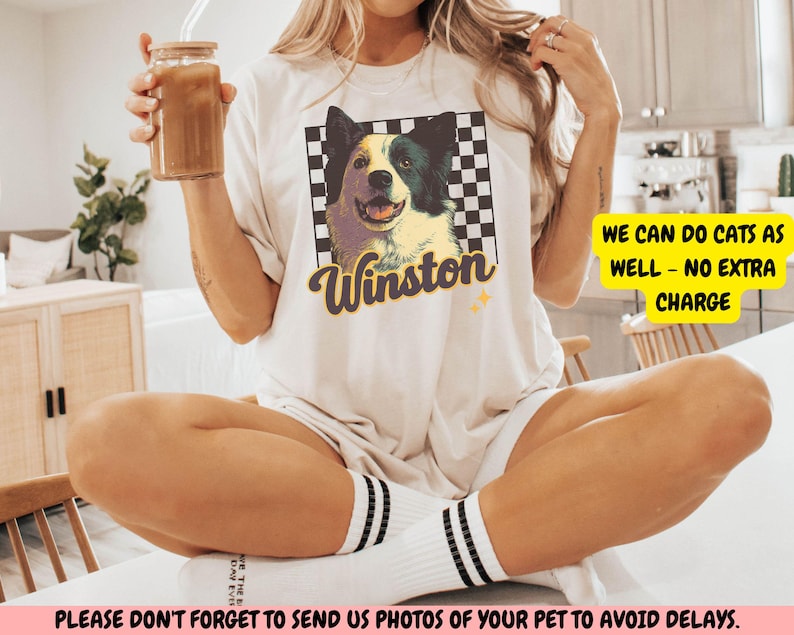 May include: Cream-colored t-shirt featuring a graphic of a dog named Winston, set against a checkered background. The text "Winston" is in a stylized font. The shirt also has the text "WE CAN DO CATS AS WELL - NO EXTRA CHARGE".
