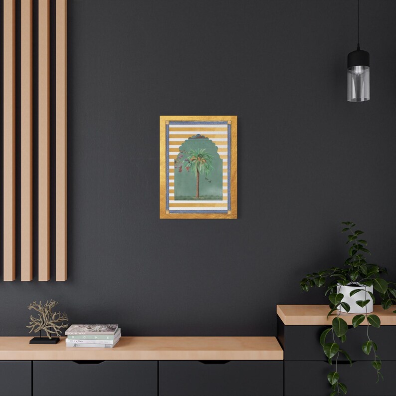 May include: A framed illustration of a palm tree with green leaves and a brown trunk, set against a background of gold and white stripes. The frame is gold with a blue border.