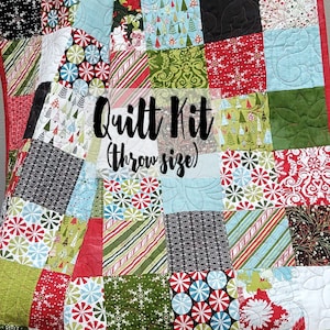 May include: A Christmas-themed quilt kit in throw size. The kit features a variety of fabrics with red, green, white, and blue colours. The fabrics have different patterns, including snowflakes, candy canes, and Christmas trees.
