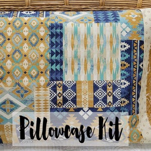 May include: A pillowcase kit featuring a patchwork design with geometric patterns in shades of blue, yellow, and white. The fabric has a distressed look and the text "Pillowcase Kit" is printed on the front.