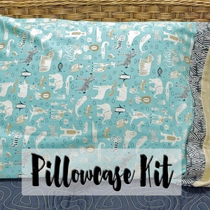 Può includere: Un kit federa con una federa turchese con un motivo animalier giocoso. Il kit include tessuto aggiuntivo con un motivo geometrico e tessuto beige a pois bianchi. Il testo "Pillowcase Kit" è visualizzato.