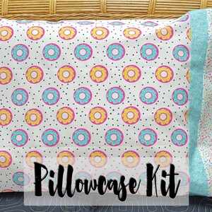 May include: A pillowcase kit featuring a donut pattern in pink, yellow, and blue on a white background. The back of the pillowcase has a blue background with colorful sprinkles.