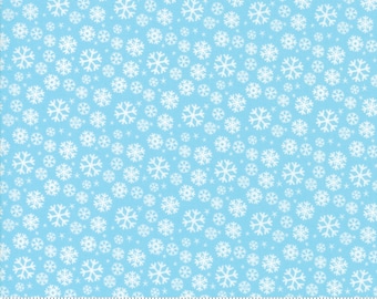 May include: A light blue fabric with a white snowflake pattern. The fabric is printed with the words "moda" and "www.modafabrics.com".